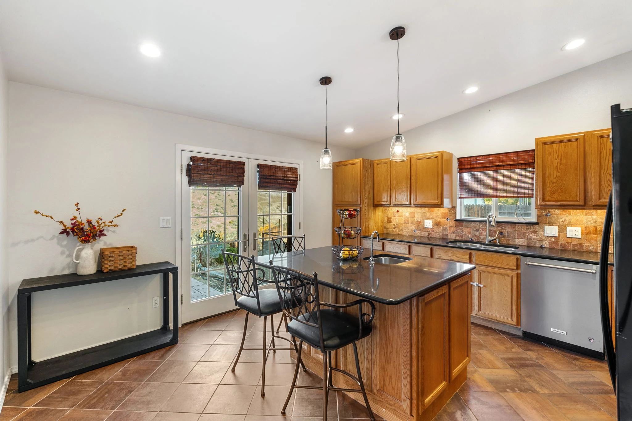 Kitchen with granite island, seating and glass doors to the deck